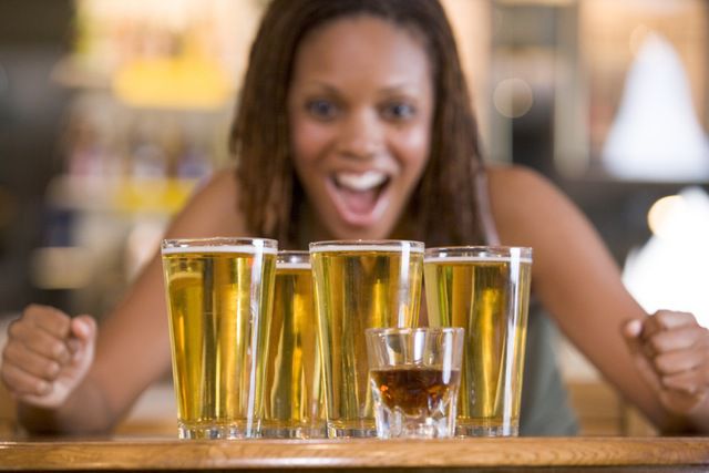 "Young woman staring excitedly at a round of beers"